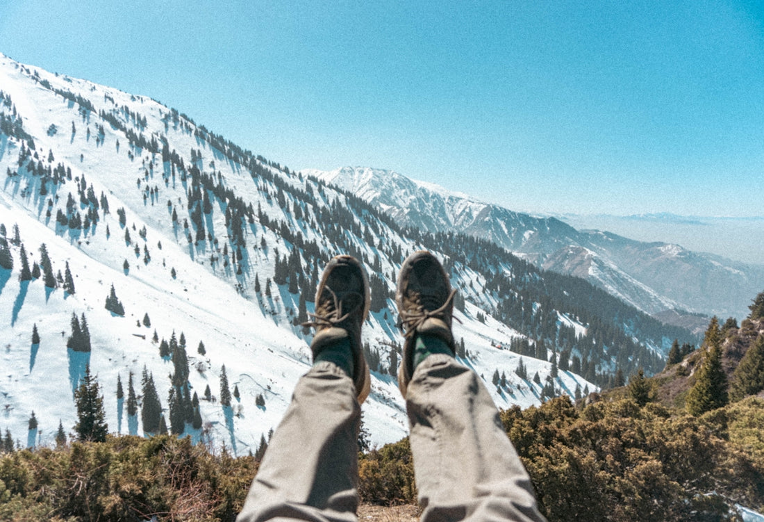 Person's legs resting with snowy mountains in background